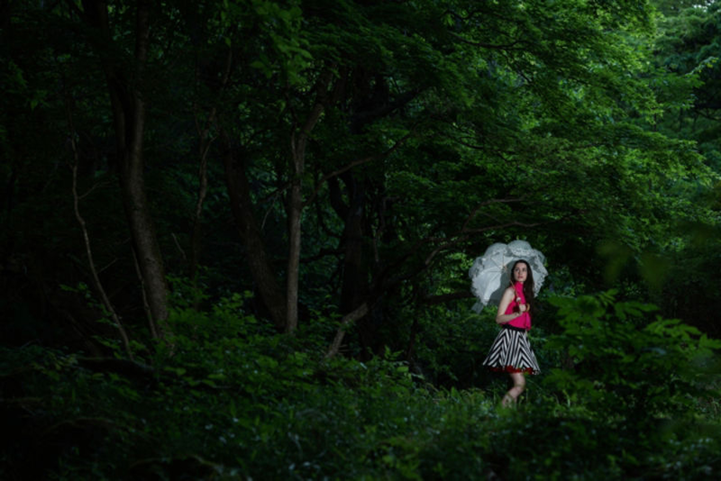 Beispielbild einer Frau mit einem Regenschirm im Wald
